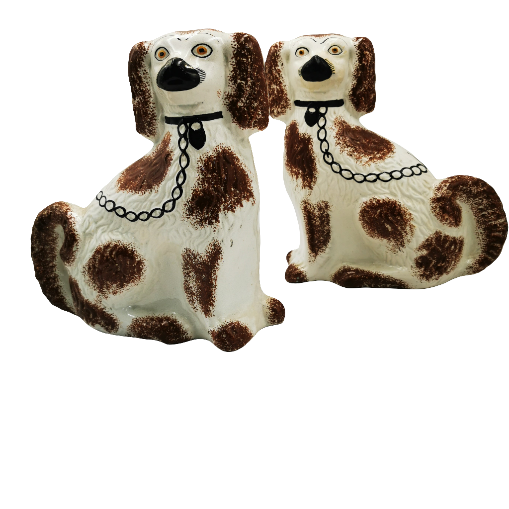 Two ceramic dog figurines with brown spots on a white background